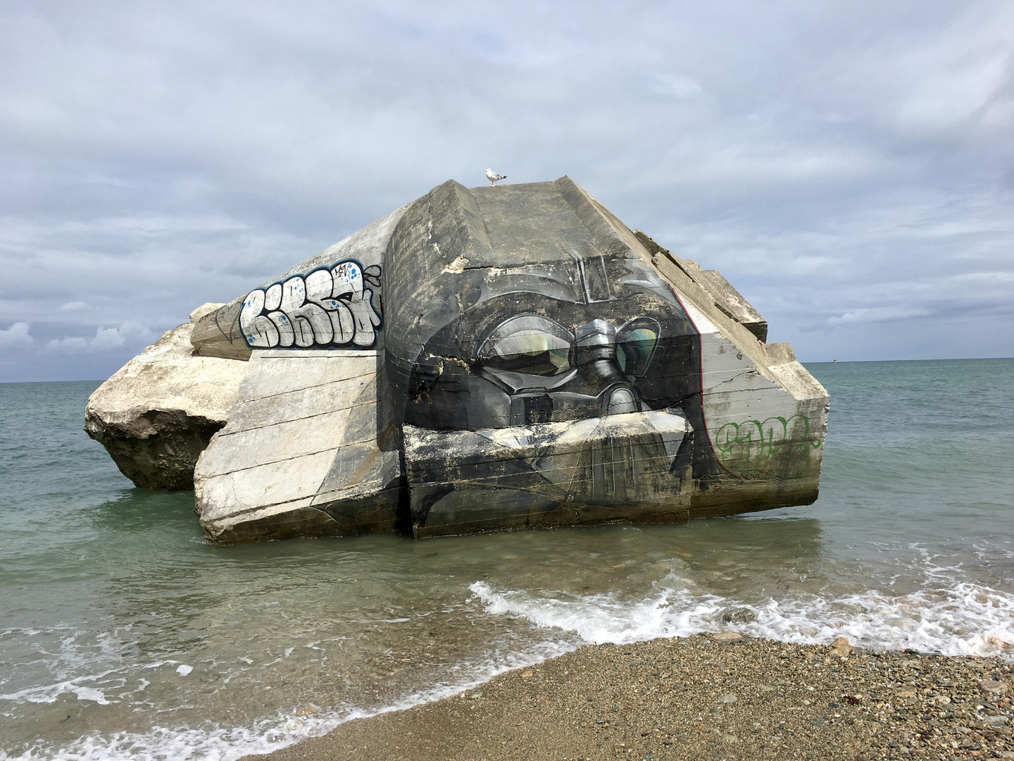 Darth Vader mit einer Möve auf einer Bunkerruine am Strand