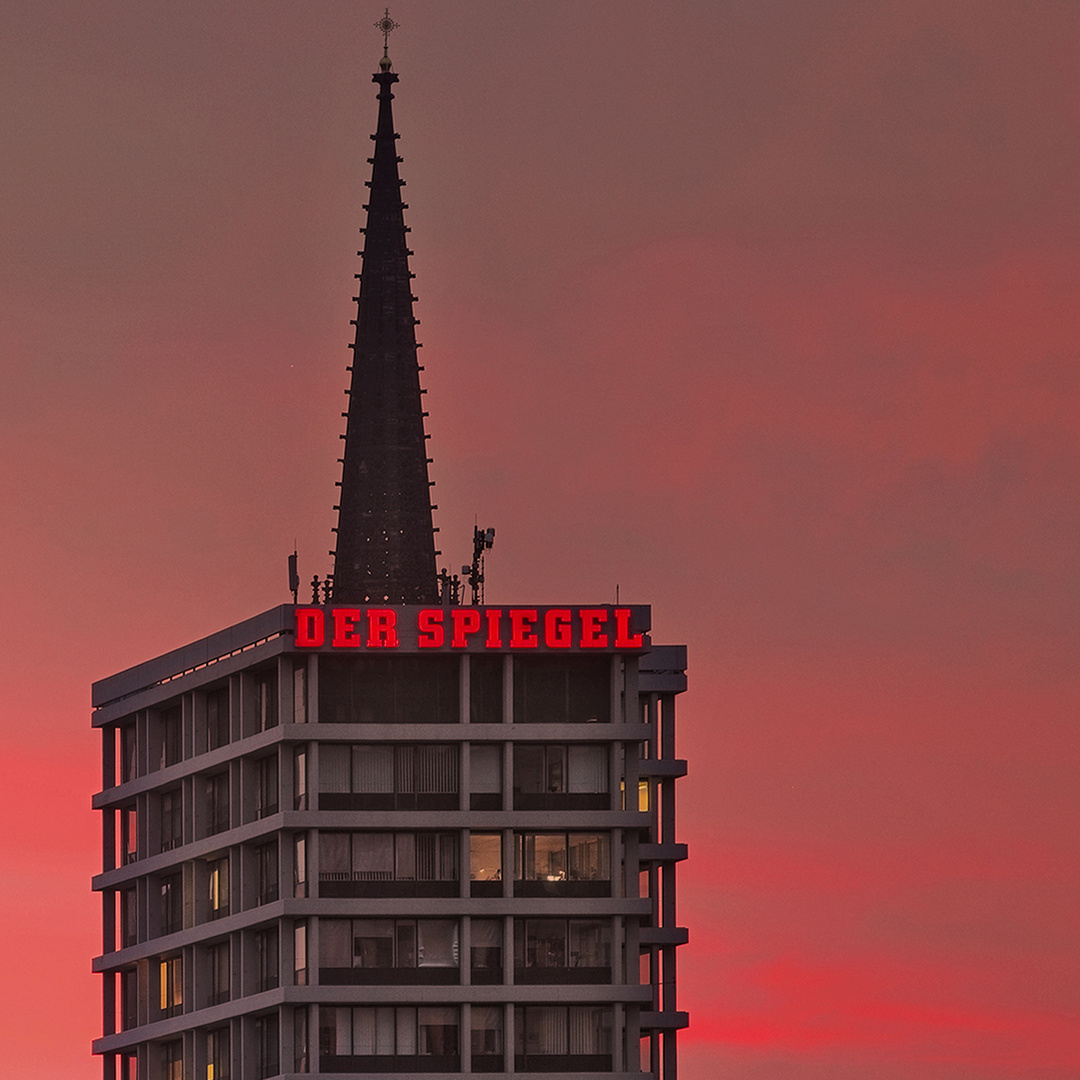 Das alte Spiegelhochhaus mit Kirchturmspitze im Hintergrund