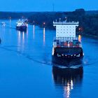 Das Containerschiff Barmbek auf dem Nord-Ostsee-Kanal zur blauen Stunde