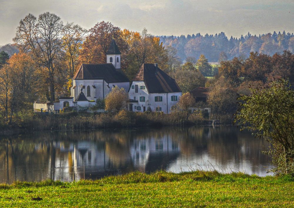 Das Pfarrhaus zwischen Kirche und See.