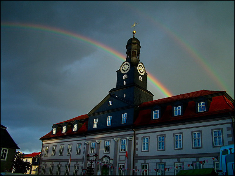 Das Rathaus in Königsee mit doppeltem Regenbogen.