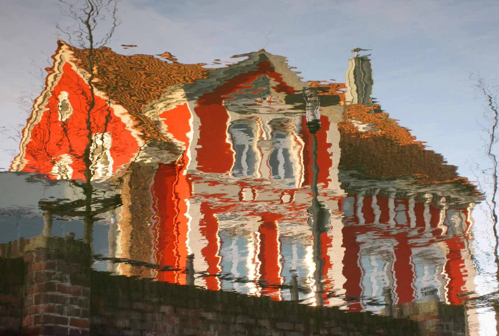 DAS ROTE HAUS in Wasser gespiegelt