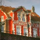 DAS ROTE HAUS in Wasser gespiegelt