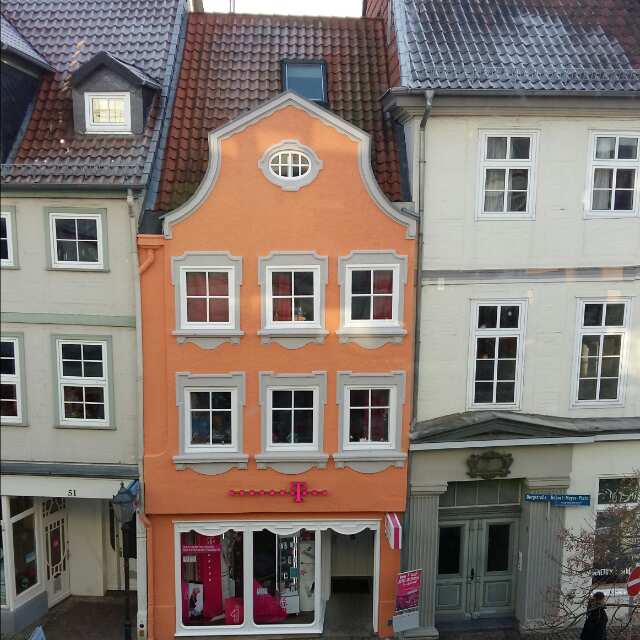 Das schwach-zart orange, eingeengte Haus in Celle