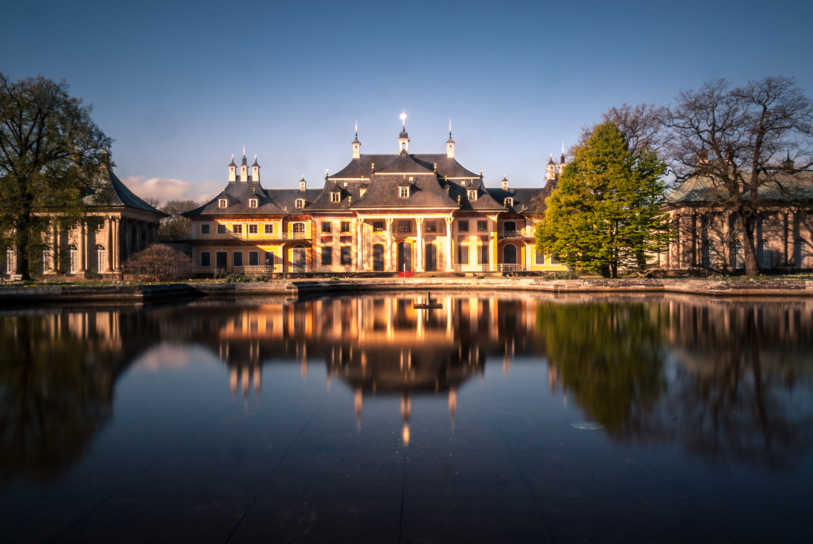 Das Wasserpalais von Schloss Pillnitz spiegelt sich im Brunnen