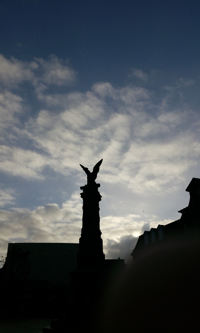 Denkmalsfigur vor Wolkenhimmel