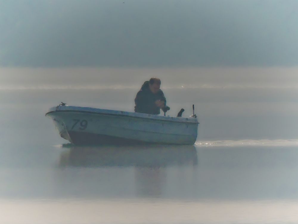 Der Angler kehrt im Nebel vom Fischfang zurück.