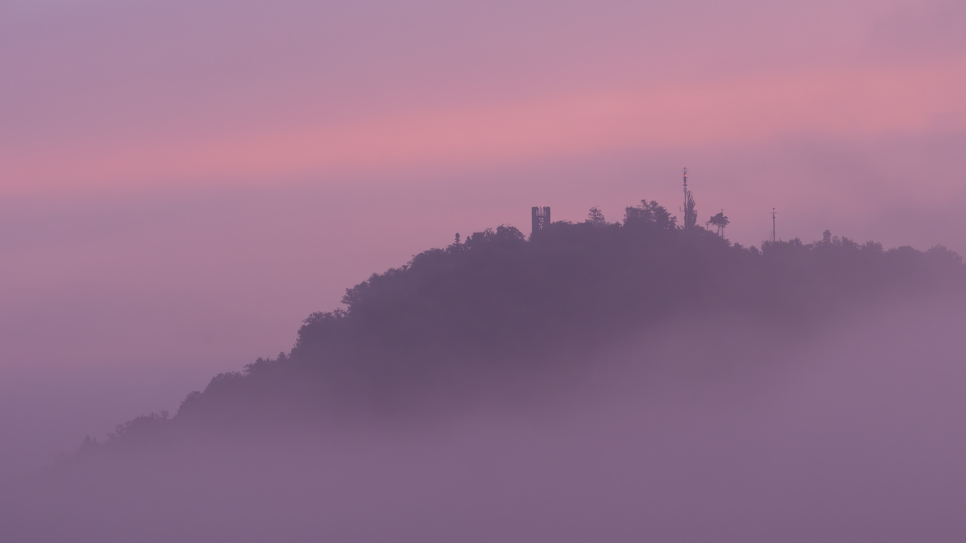 Der Berner Hausberg Gurten verschwindet im Nebel, farblich in Szene gesetzt mit dem Morgenrot