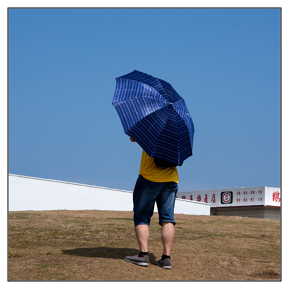 der blaue Schirm am weissen Leuchtturm