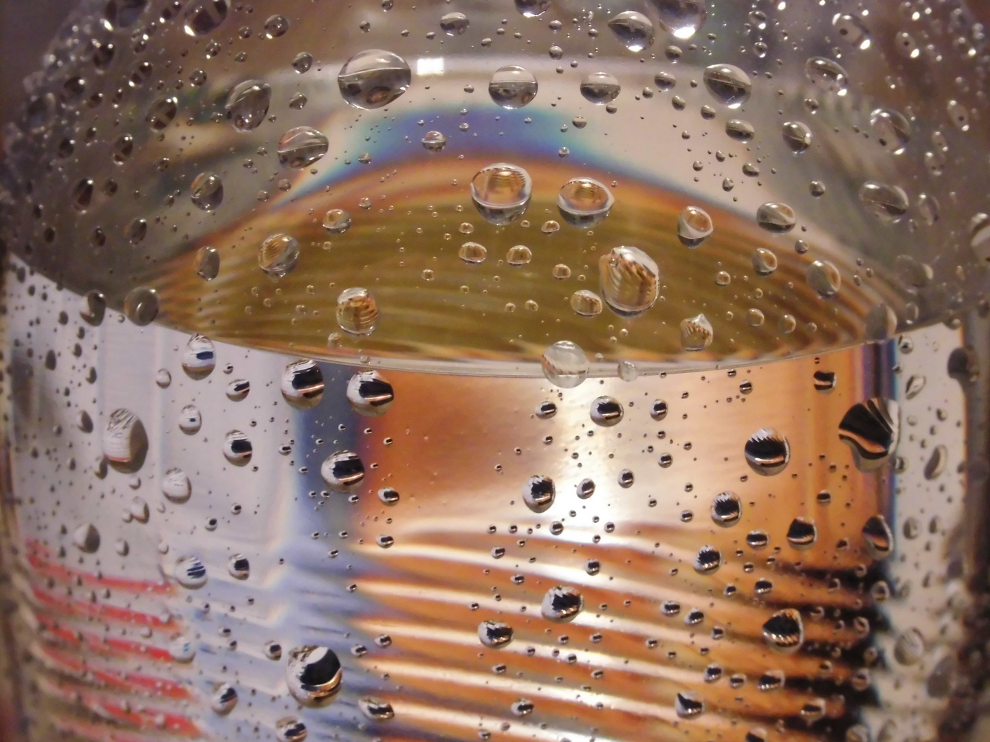 Der Blick auf eine Wasserflasche mit Wassertropfen....