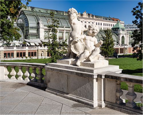 Der Burggarten mit Skulptur und dem Palmenhaus im Hintergrund