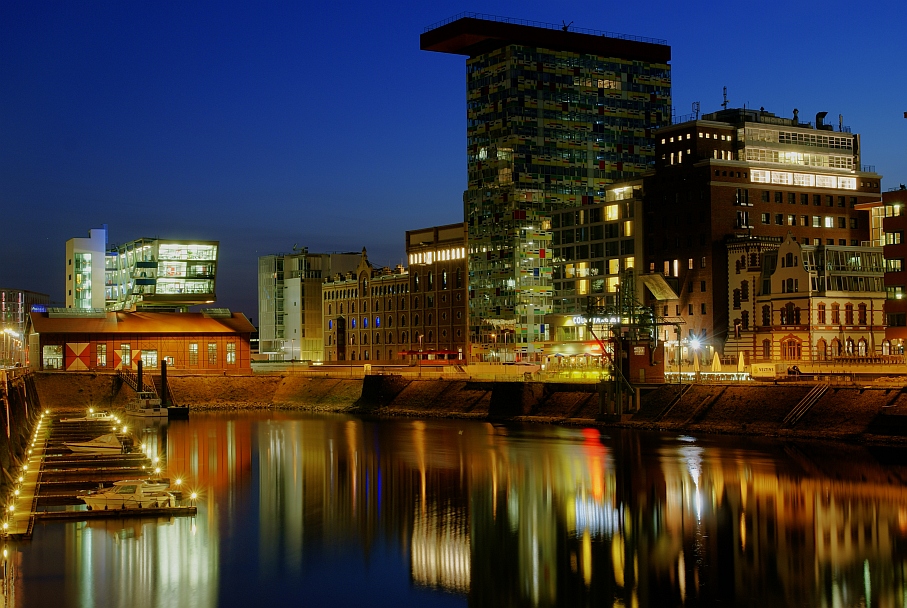 Der Düsseldorfer Medienhafen illuminiert im Abendlicht.