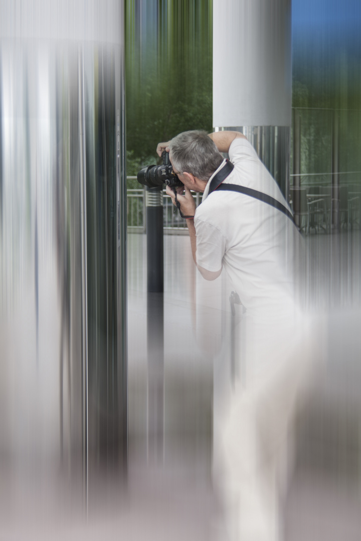 Der Fotograf fotografiert sich im Spiegel der Säule selbst