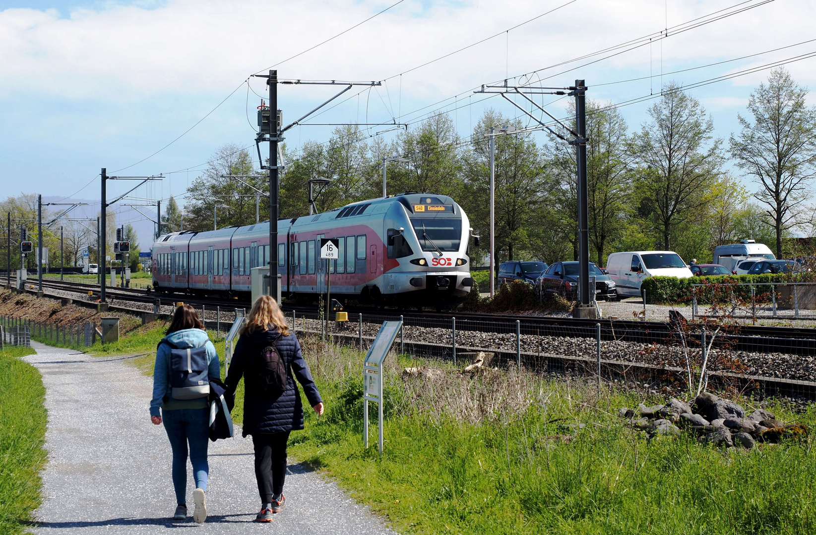 Der Fußweg, die Schiene und der Parkplatz