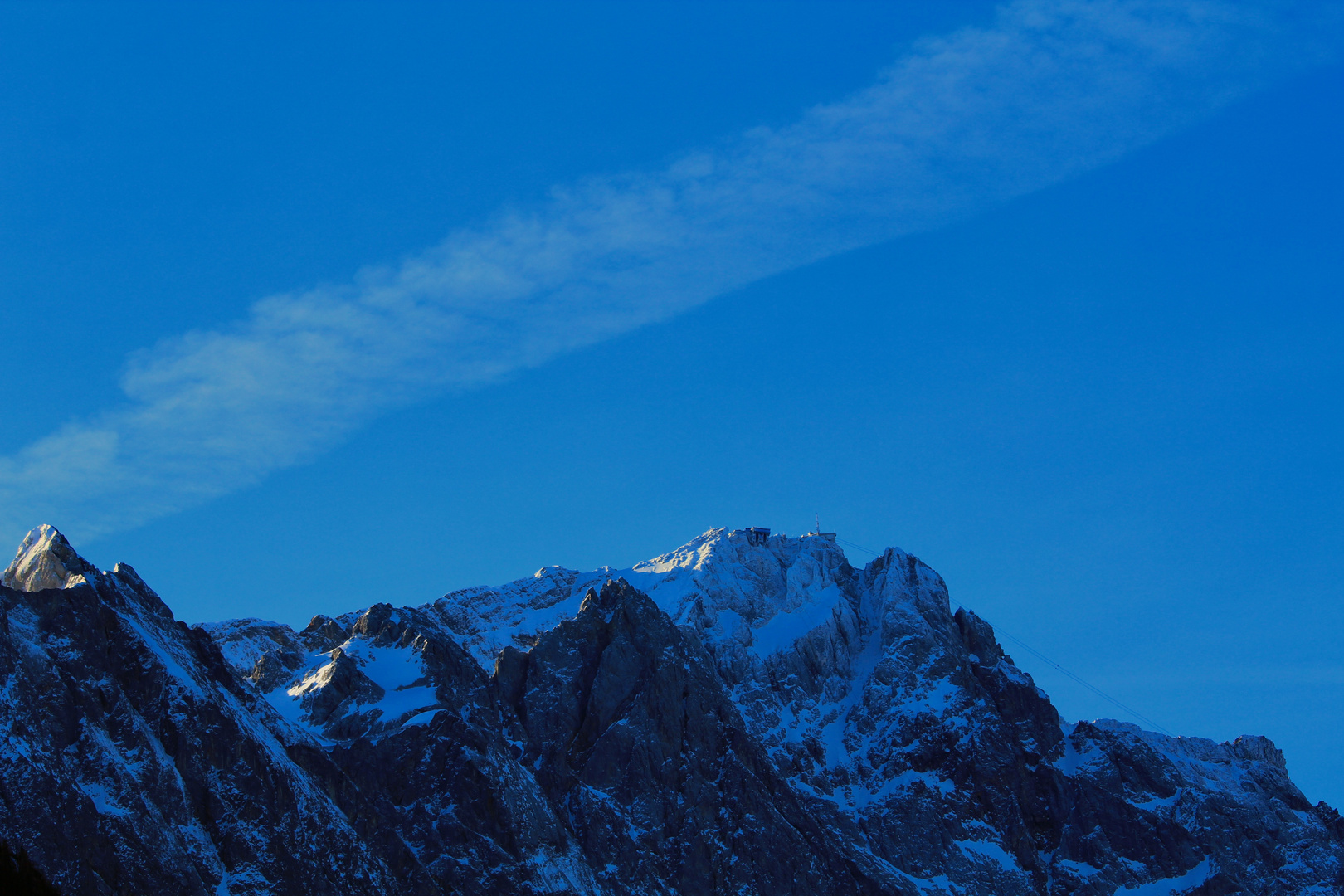 Der Gipfel der Zugspitze erwacht an einem Wintermorgen mit den ersten wärmenden Sonnenstrahlen