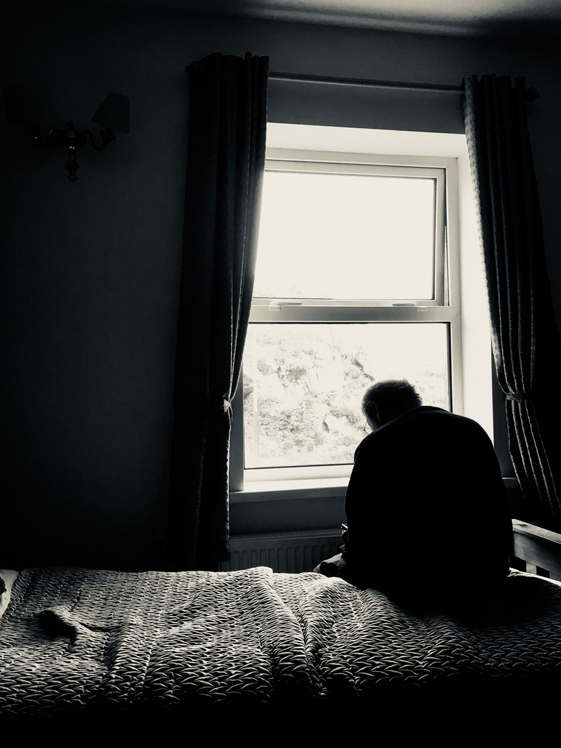 der holde sitzt am fenster, aber schaut nicht raus Foto