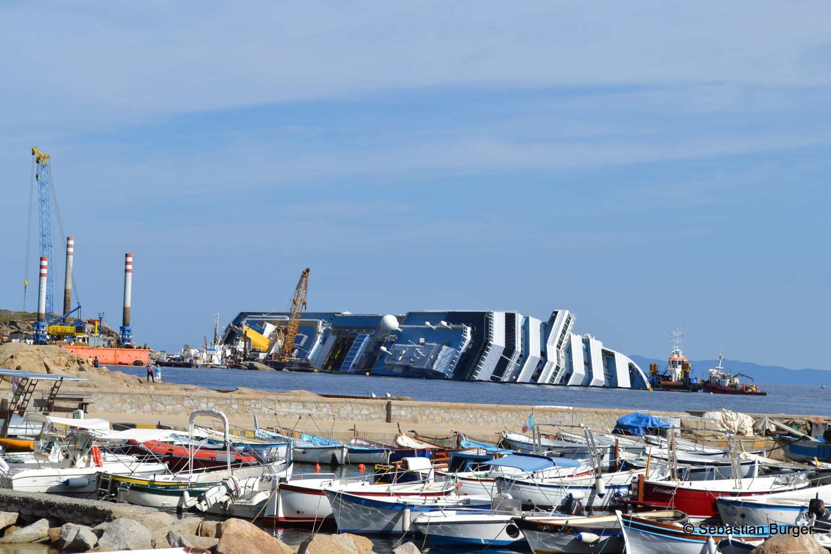 Der Jachthafen auf Giglio - Im Hintergrund die auf Grund gelaufene Costa Concordia