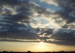 Der letzte Sonnenschein schaut unter den Wolken hervor bevor sie ganz verschwindet