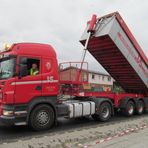 der LKW kippt den Asphalt in die Maschine ..........