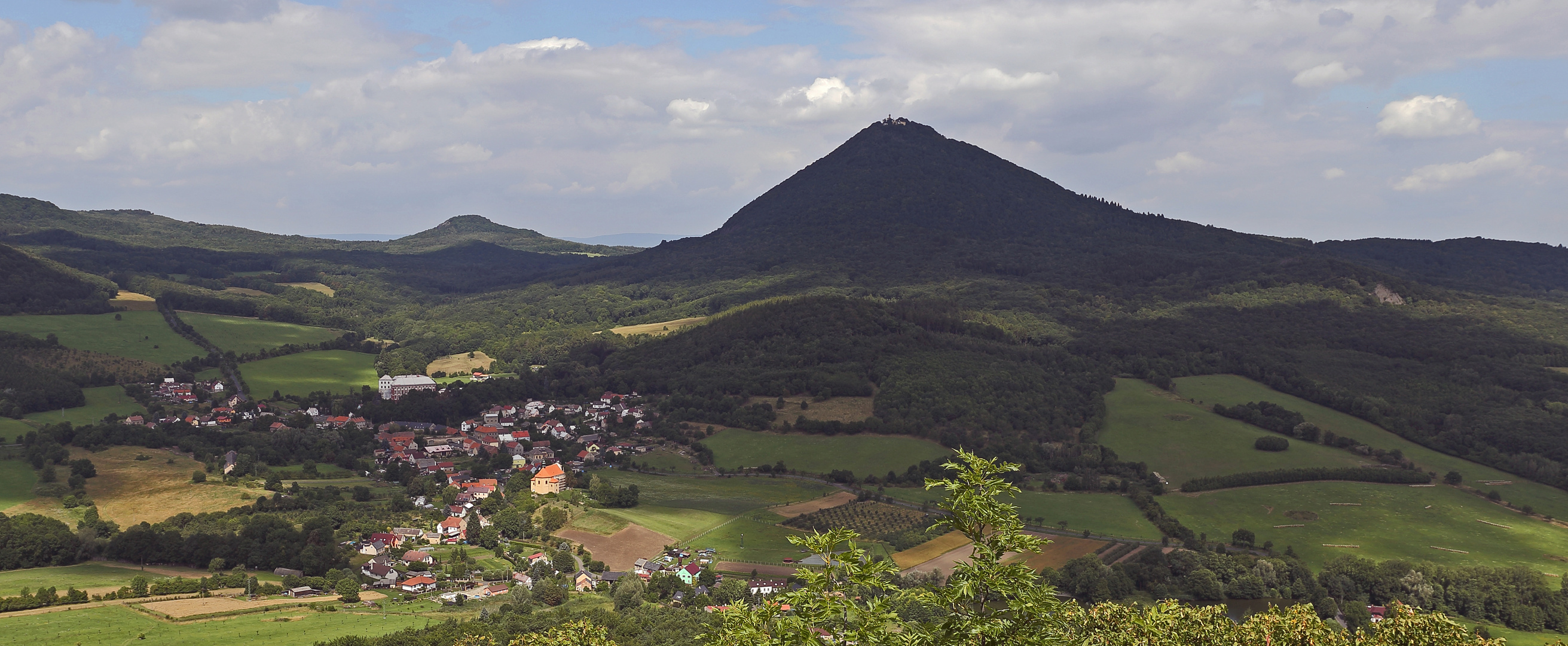 Der Milesovka und das Dorf Milesov sind vom Ostry sehr gut zu sehen