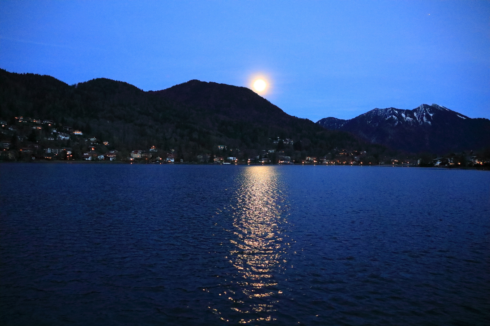Der Mond erscheint am Himmel und leuchtet auf den See