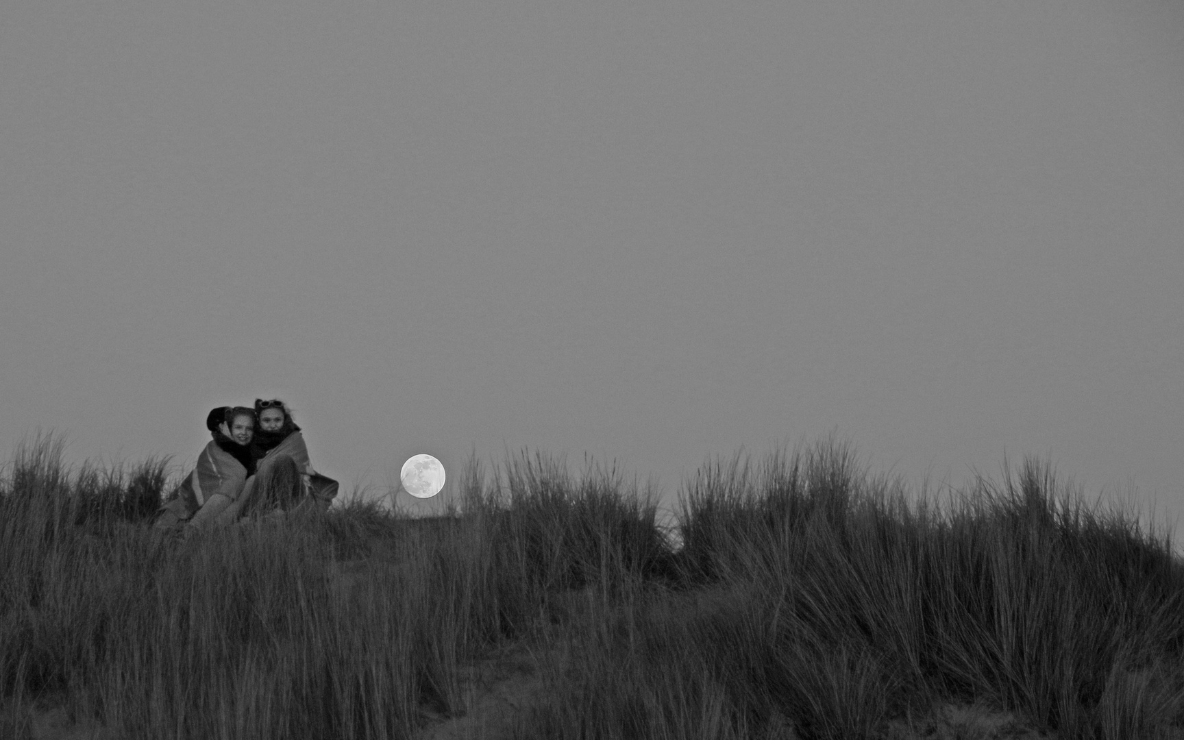 Der Mond in Betrachtung zweier Mädchen.