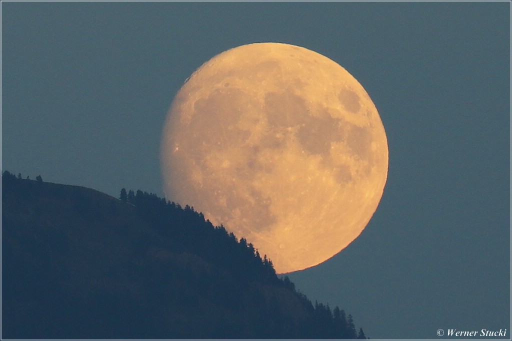 Der Mond kommt langsam hinter dem Geländ hervor