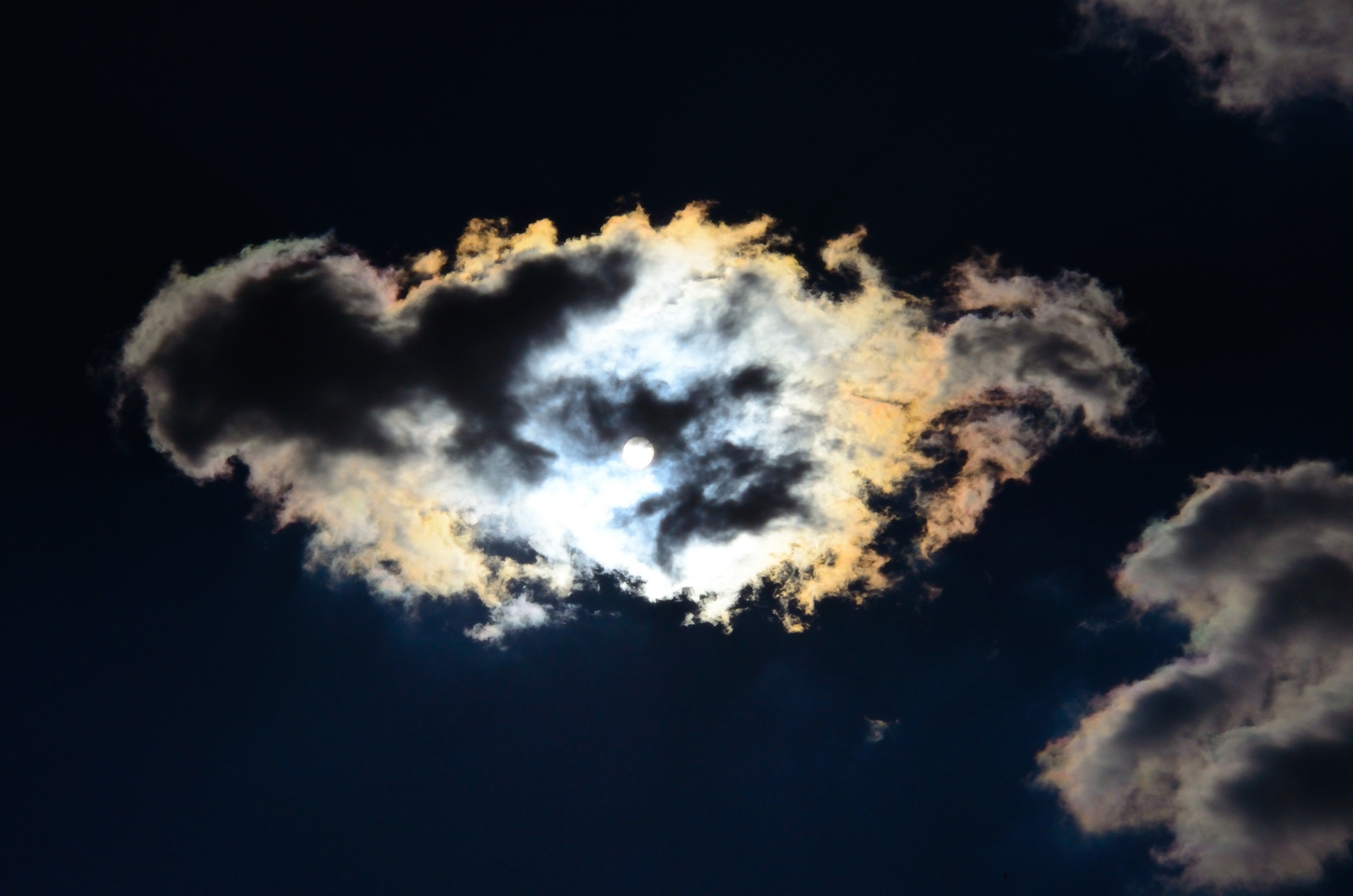 Der Mond leuchtet von hinten die Wolken an.