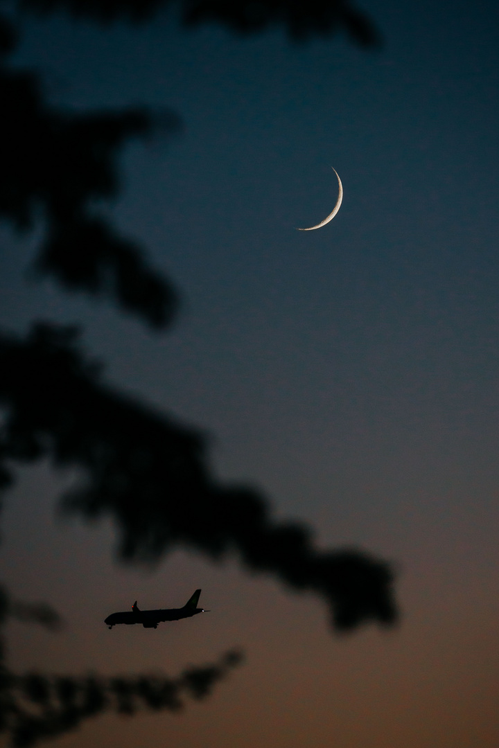 Der Mond und anfliegende Flugzeuge