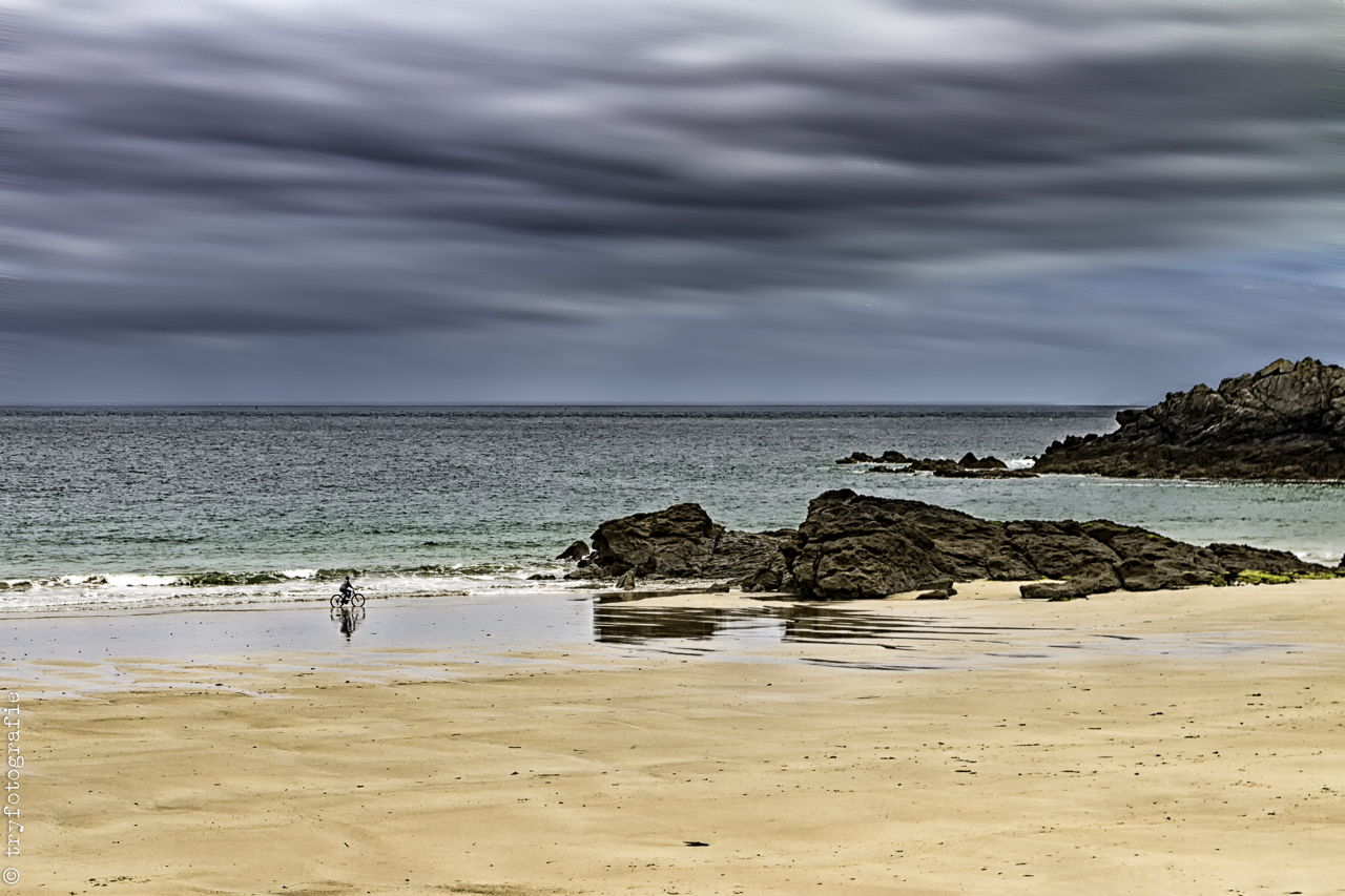 Der Radfahrer am Strand