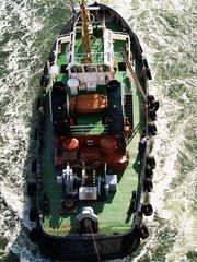 Der Schlepper BUGSIER bugsiert ein Kreuzfahrtschiff durch die Mitte des Brückenbogen durch.