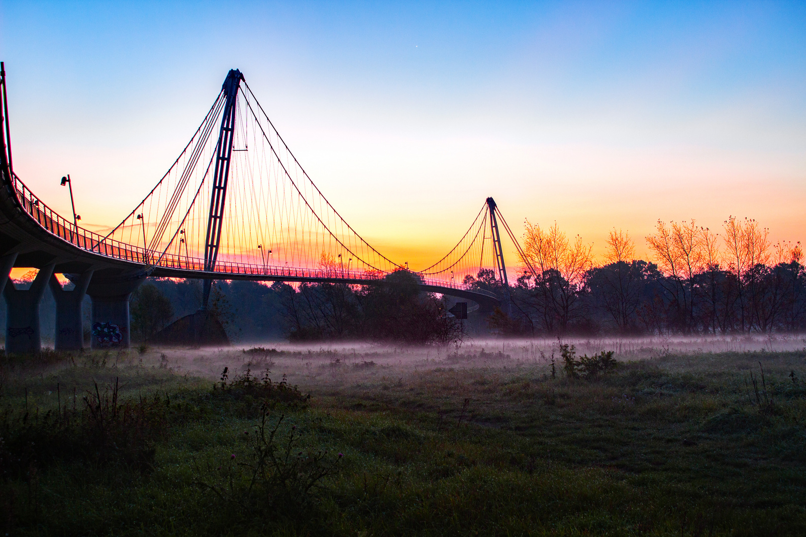 der Sonnenaufgang hinter der Brücke