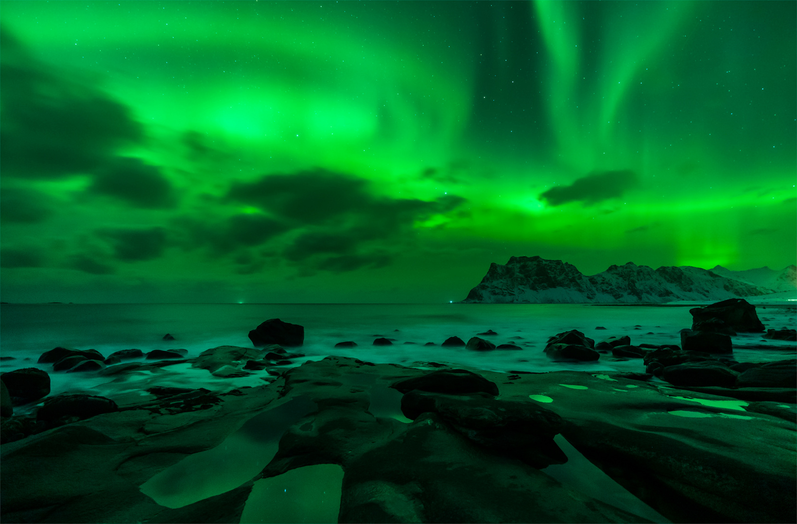 Der Strand von Uttakleiv wird von einer wunderschönen Aurora beleuchtet