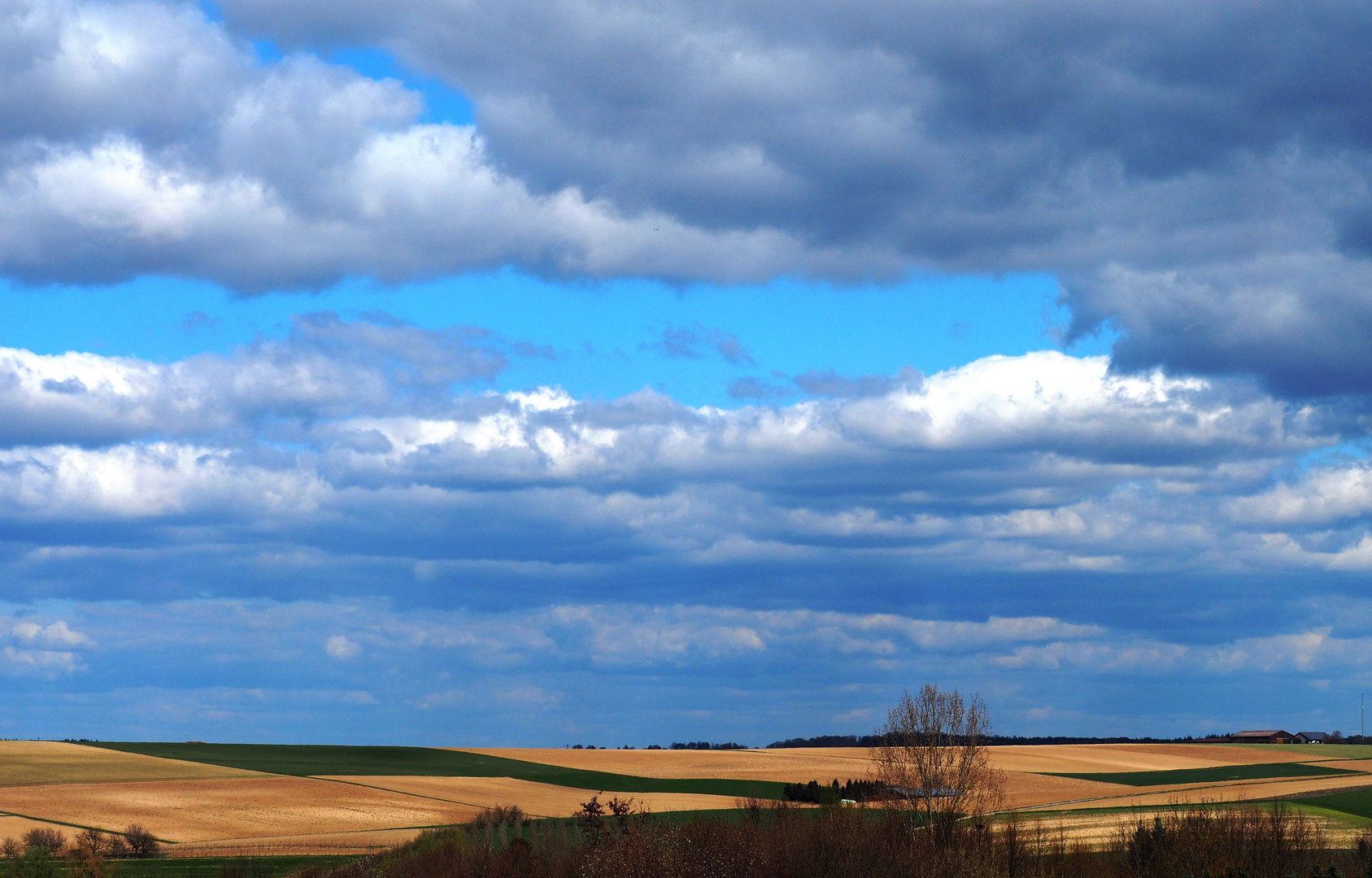Der Wolkenhimmel über den Feldern