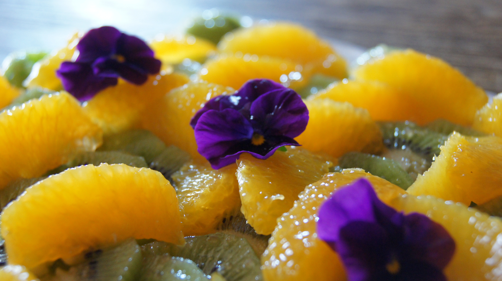 Des couleurs dans l'assiette,Salade de kiwis aux suprêmes d'oranges et fleurs de pensée.