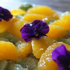 Des couleurs dans l'assiette,Salade de kiwis aux suprêmes d'oranges et fleurs de pensée.