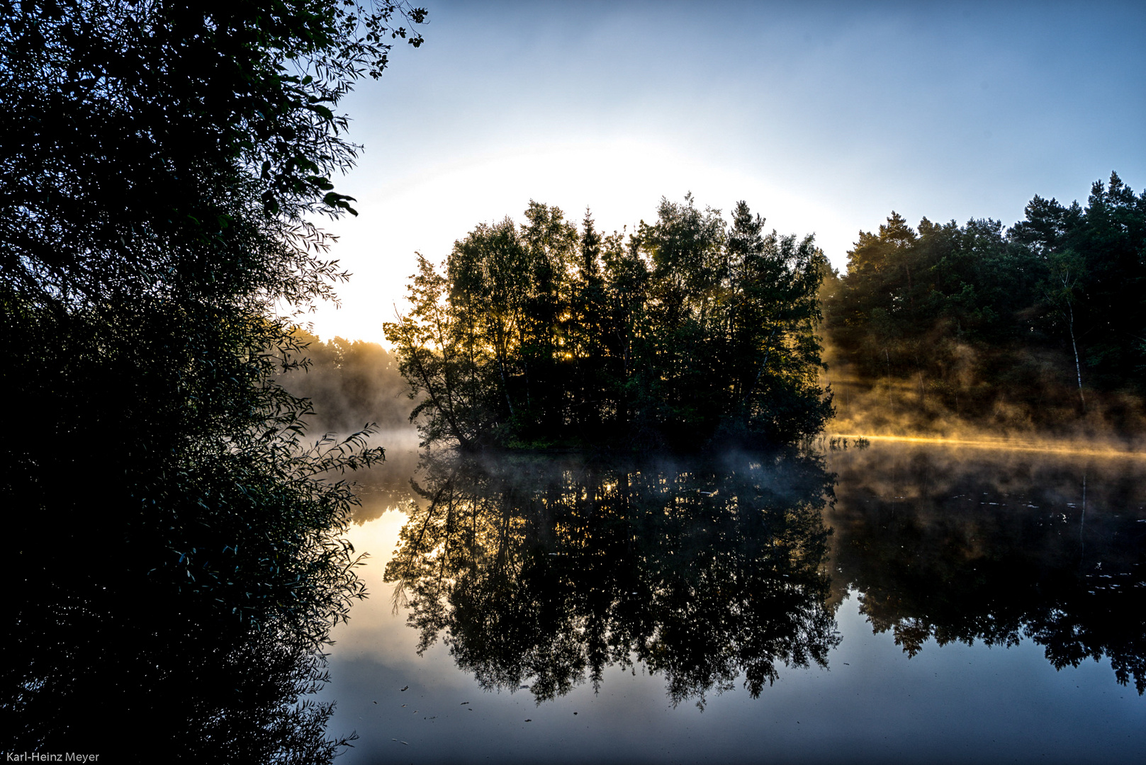 Die ersten Sonnenstrahlen des Tages im Nebel verfangen.