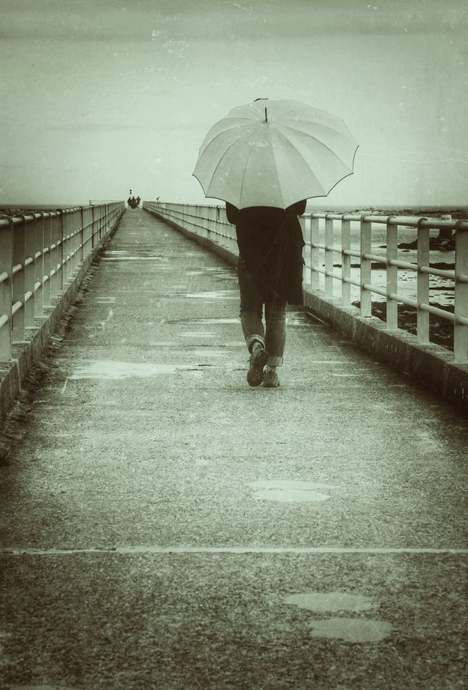 Die Frau mit dem Regenschirm, geht über die Brücke der Erinnerungen