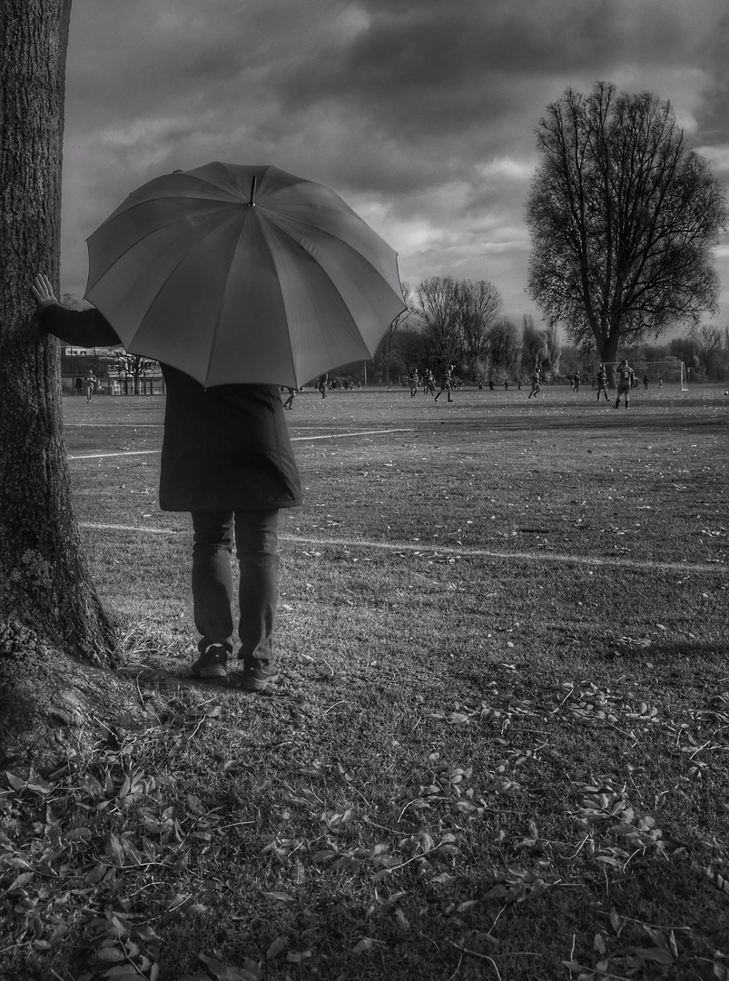 Die Frau mit dem Regenschirm; schaut beim Fussball zu. (27)