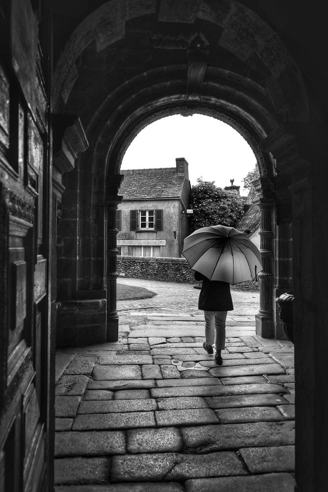 Die Frau mit dem Regenschirm verlässt die Eglise Saint-Miliau (70)