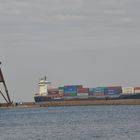 die Kugelbake in Cuxhaven mit einem Containerschiff im Hintergrund