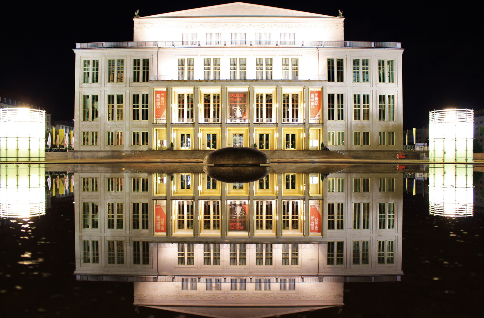 Die Leipziger Oper bei Nacht gespiegelt im Wasser