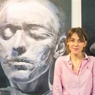 Die Malerin Salome Rigvava vor ihren  Selbstportraits 