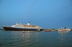 Die "Marco Polo" verlässt Warnemünde mit Fahrgastschiffen im Schlepptau