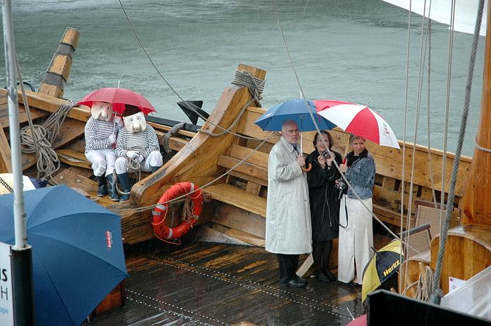 Die Prominenz steht im Regen, sowie das Personal