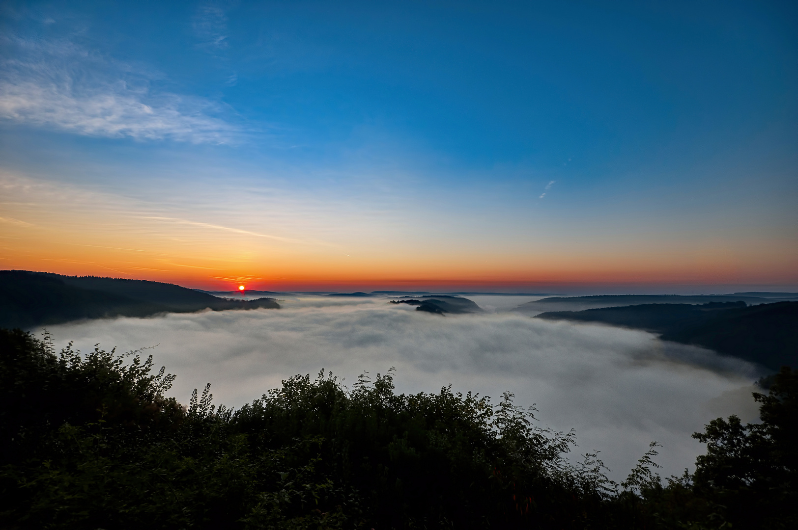 Die Saarschleife bei Sonnenaufgang im Morgennebel