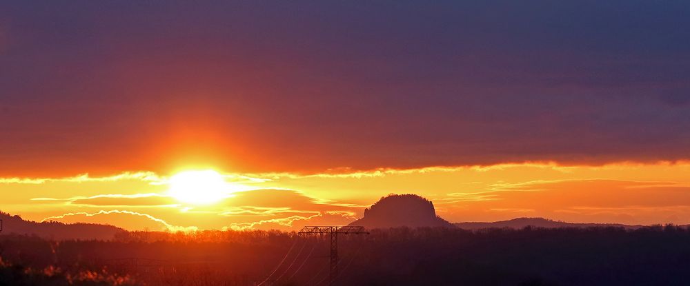 Die Sonne begann in den dunklen Wolkenstreifen auf zu steigen...