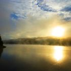 Die Sonne durchbricht den über der Talsperre liegenden zähen Nebel