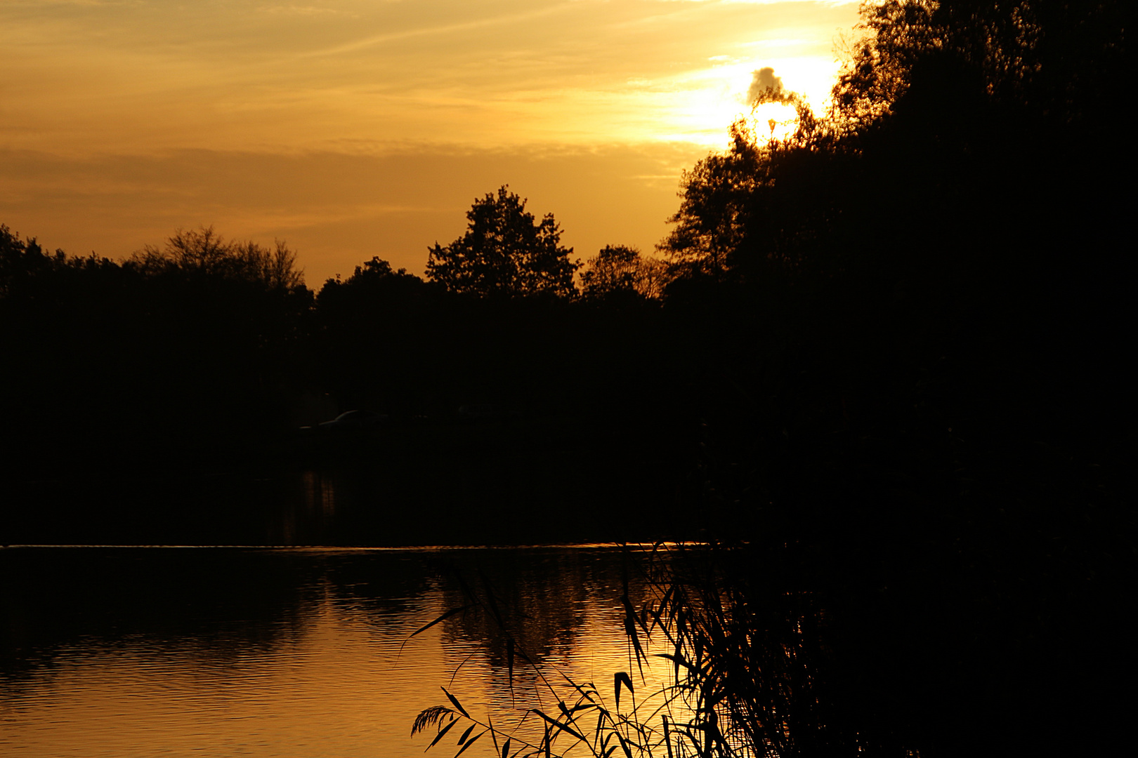 die Sonne färbt Himmel und See