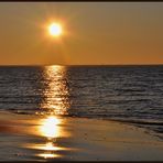 Die Sonne geht am goldenen Strand von Langeoog